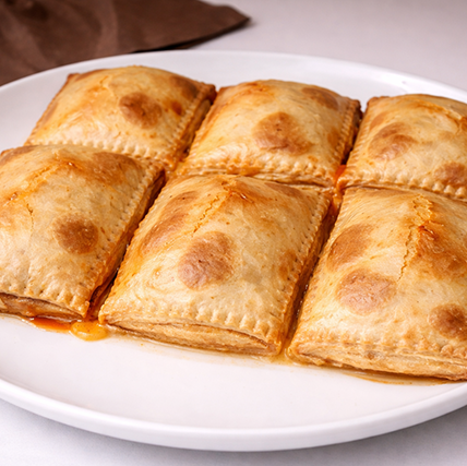 8Empanadas doradas en plato blanco